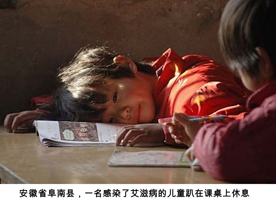 安徽省阜南县，一名感染了艾滋病的儿童趴在课桌上休息